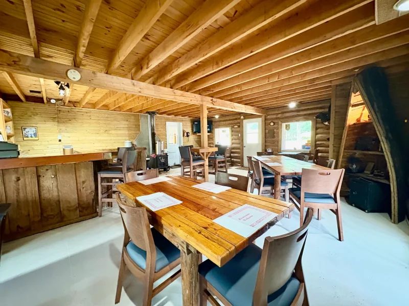 La salle à manger de l'auberge avec ses tables en bois et son ambiance rustique.