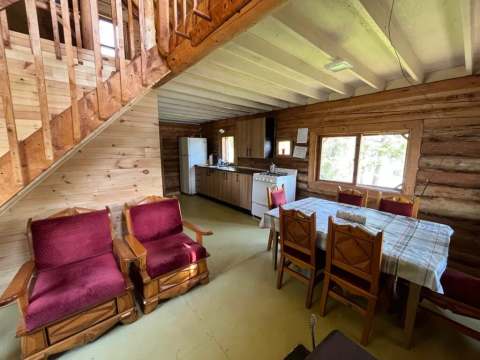 L'aire ouverte du chalet comprend une cuisine équipée, une salle à manger et un coin détente.