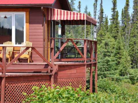 This inn features an outdoor deck furnished with chairs and an awning.
