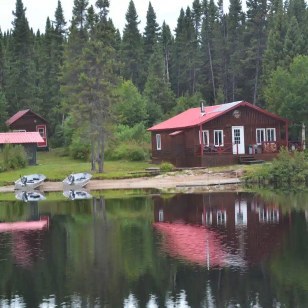 Le chalet Point 1 se situe au bord de l'eau avec des embarcations à proximité.