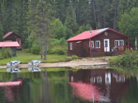 Le chalet Point 1 se situe au bord de l'eau avec des embarcations à proximité.