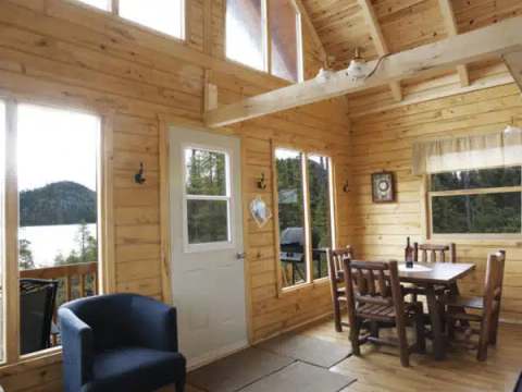 Vue de l'intérieur du chalet avec ses plafonds hauts et son coin salle à manger.