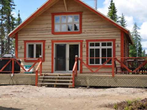 Vue extérieure du chalet Point 4 avec sa grande terrasse en bois et son accès principal.