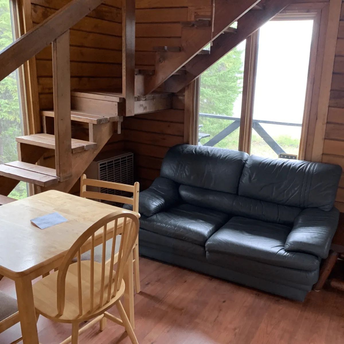 The chalet's living and dining area with its wooden staircase and comfortable sofa.