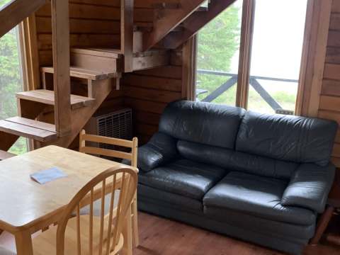 The chalet's living and dining area with its wooden staircase and comfortable sofa.