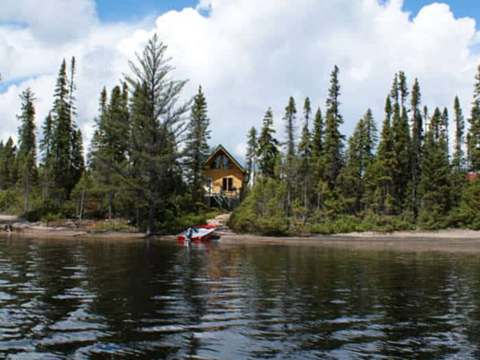 The Point 2 cabin is located on the lakeshore, surrounded by forest.