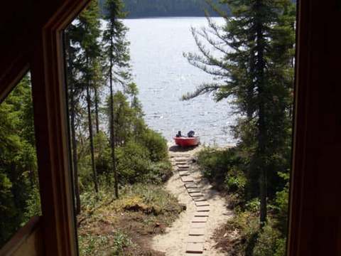 View of the path leading to the lake and boat from inside the cabin.