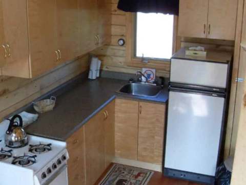 The chalet's equipped kitchen features a stove, a refrigerator, and wooden countertops.