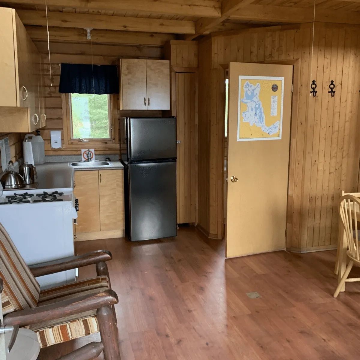 The functional kitchen of the cottage includes a refrigerator, a stove, and a dining table.