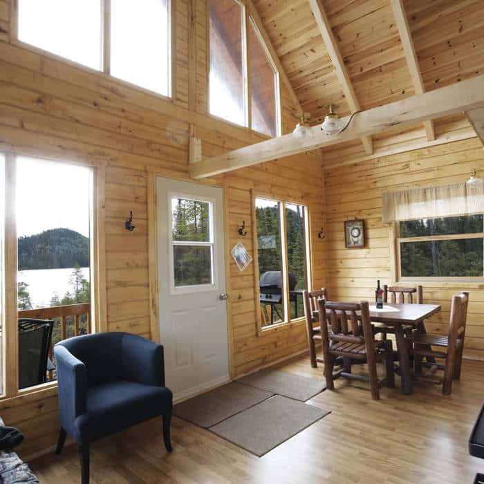 L'aire de séjour lumineuse du Chalet Point 3 dispose d'une table à manger et d'une vue sur le lac.