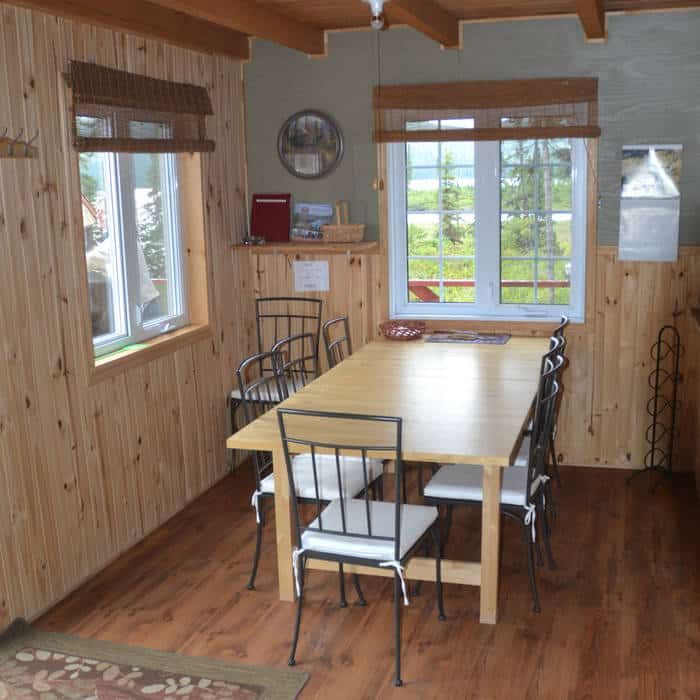 The cottage dining room features a wooden table and comfortable chairs.