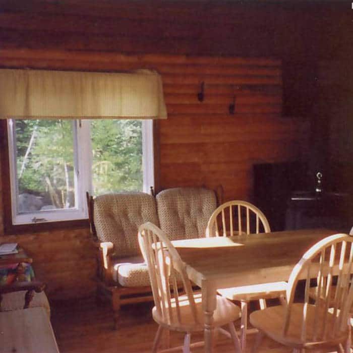 The cottage dining area is furnished with a wooden table and comfortable chairs.