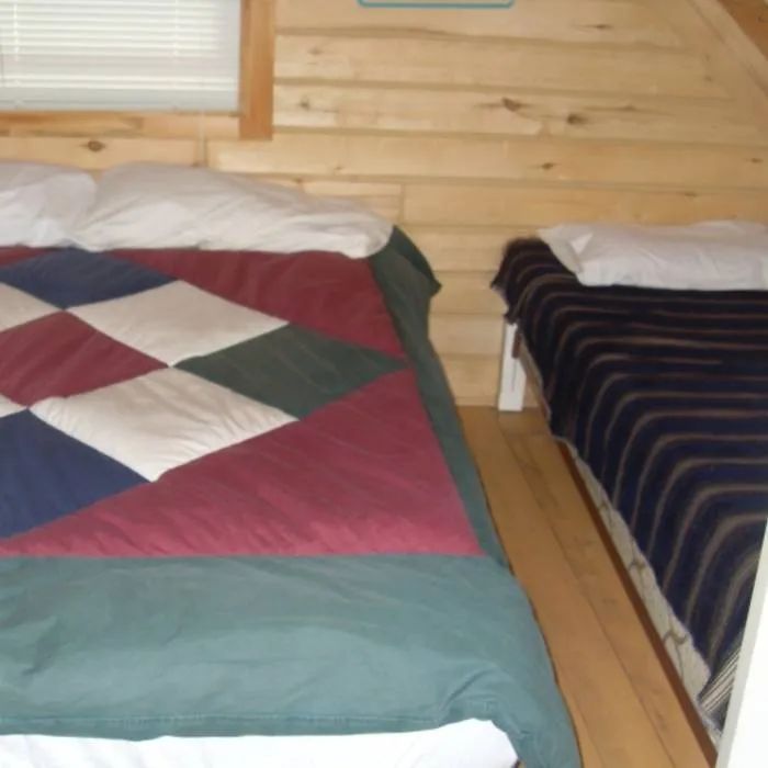 The cabin bedroom features two beds with comfortable quilts.