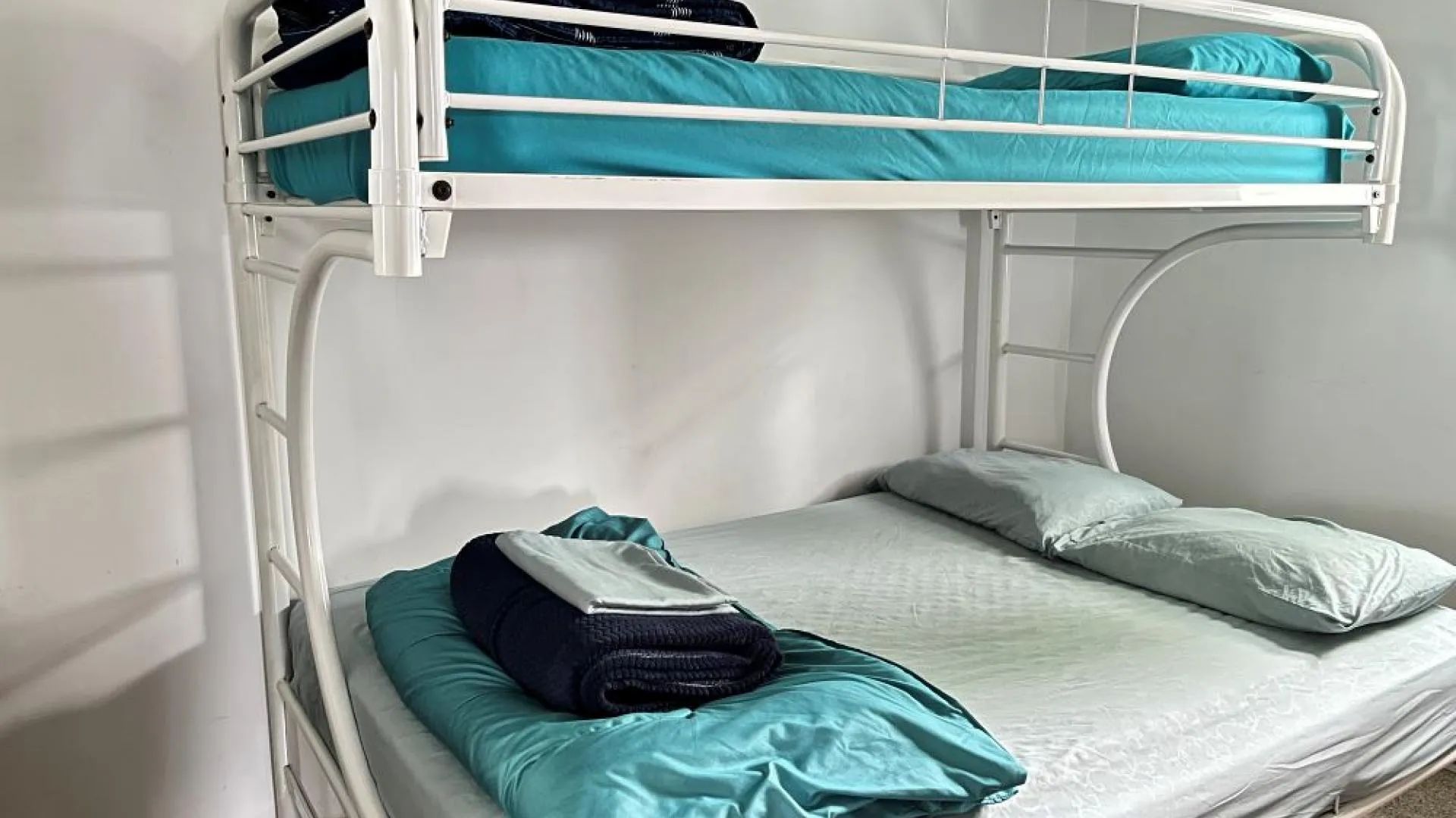 Un lit superposé avec literie bleue se trouve dans la chambre du chalet Le Garrot.