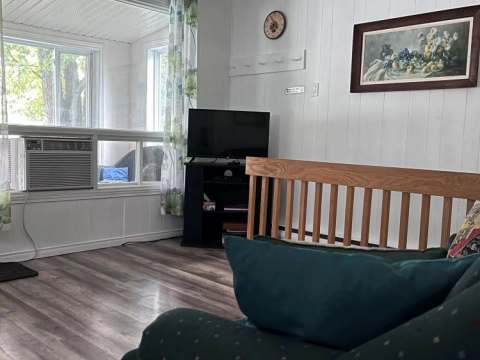 Le salon du chalet est aménagé avec un canapé confortable et une télévision.