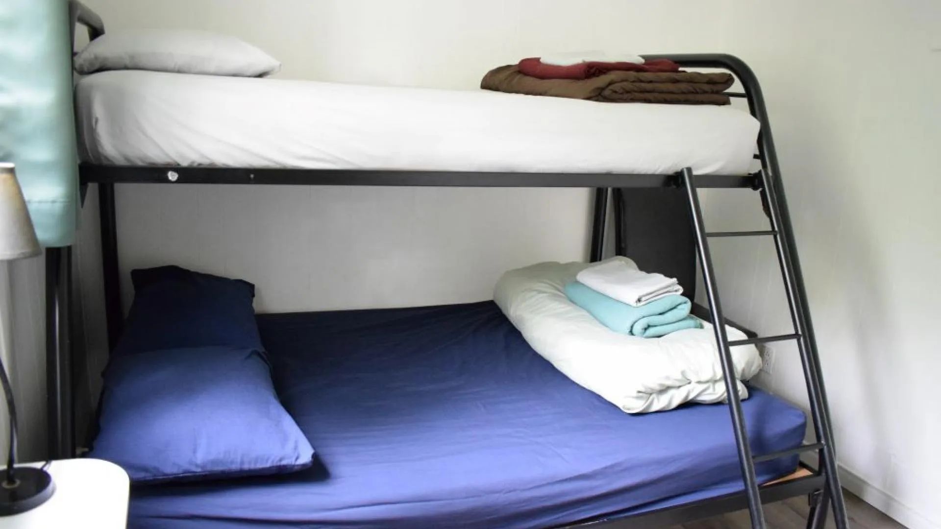 Un lit superposé équipé de draps et couvertures dans une chambre du chalet.