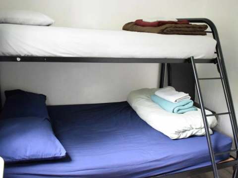 Un lit superposé équipé de draps et couvertures dans une chambre du chalet.