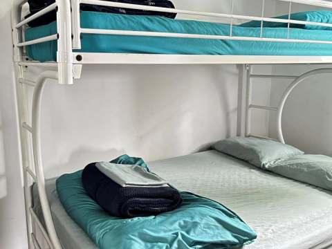 A bunk bed with blue bedding is located in the Le Garrot cabin bedroom.