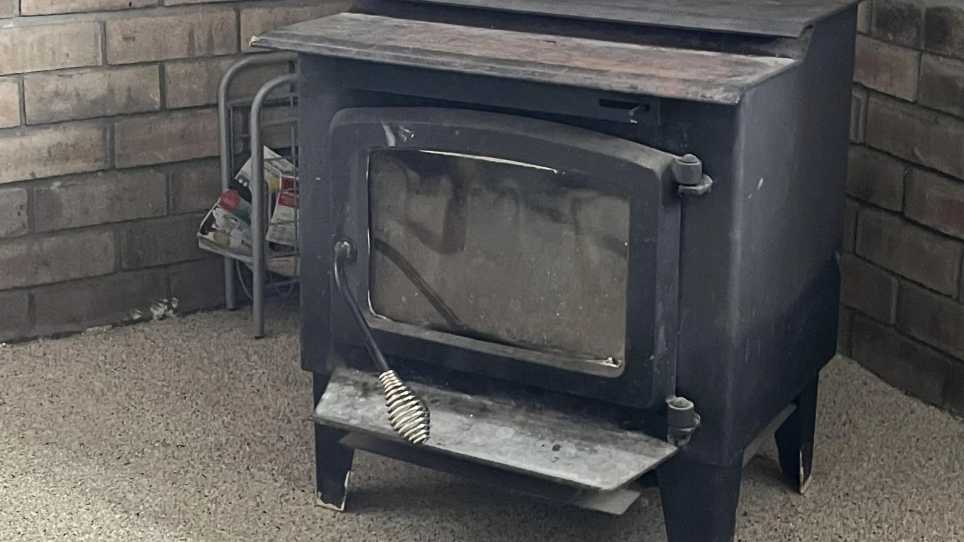 A cast iron wood stove is installed in the cabin's living room.