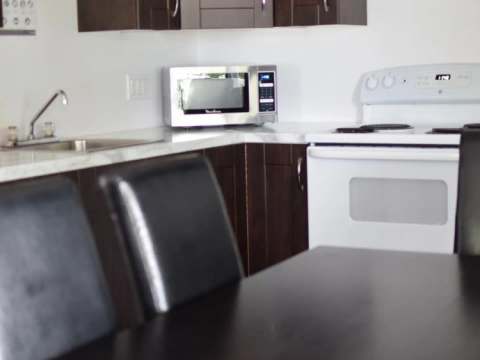 The cottage's functional kitchen includes a stove, a microwave, and a dining area.