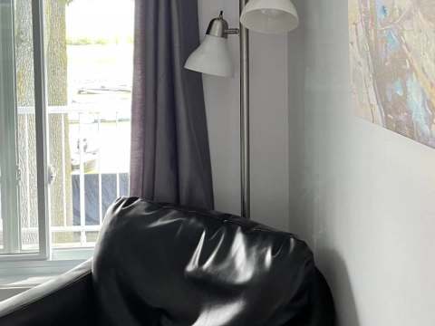 A comfortable armchair near the window with a view of the dock and boats.