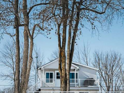 The Garrot cottage is located in the forest, surrounded by mature trees in winter.