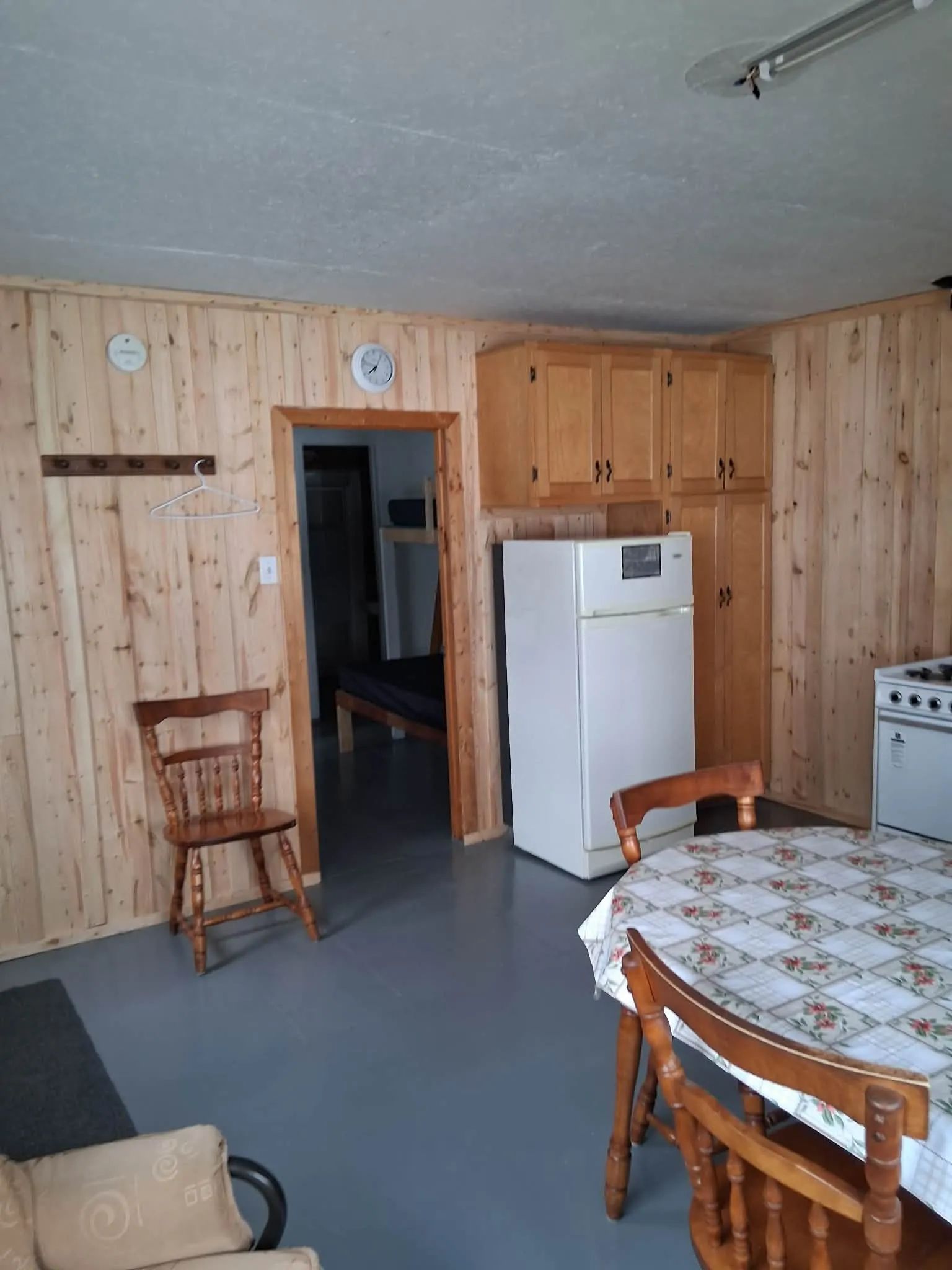 The functional kitchen of the Le Huard cottage is equipped with a dining table and a refrigerator.