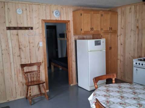 The functional kitchen of the Le Huard cottage is equipped with a dining table and a refrigerator.