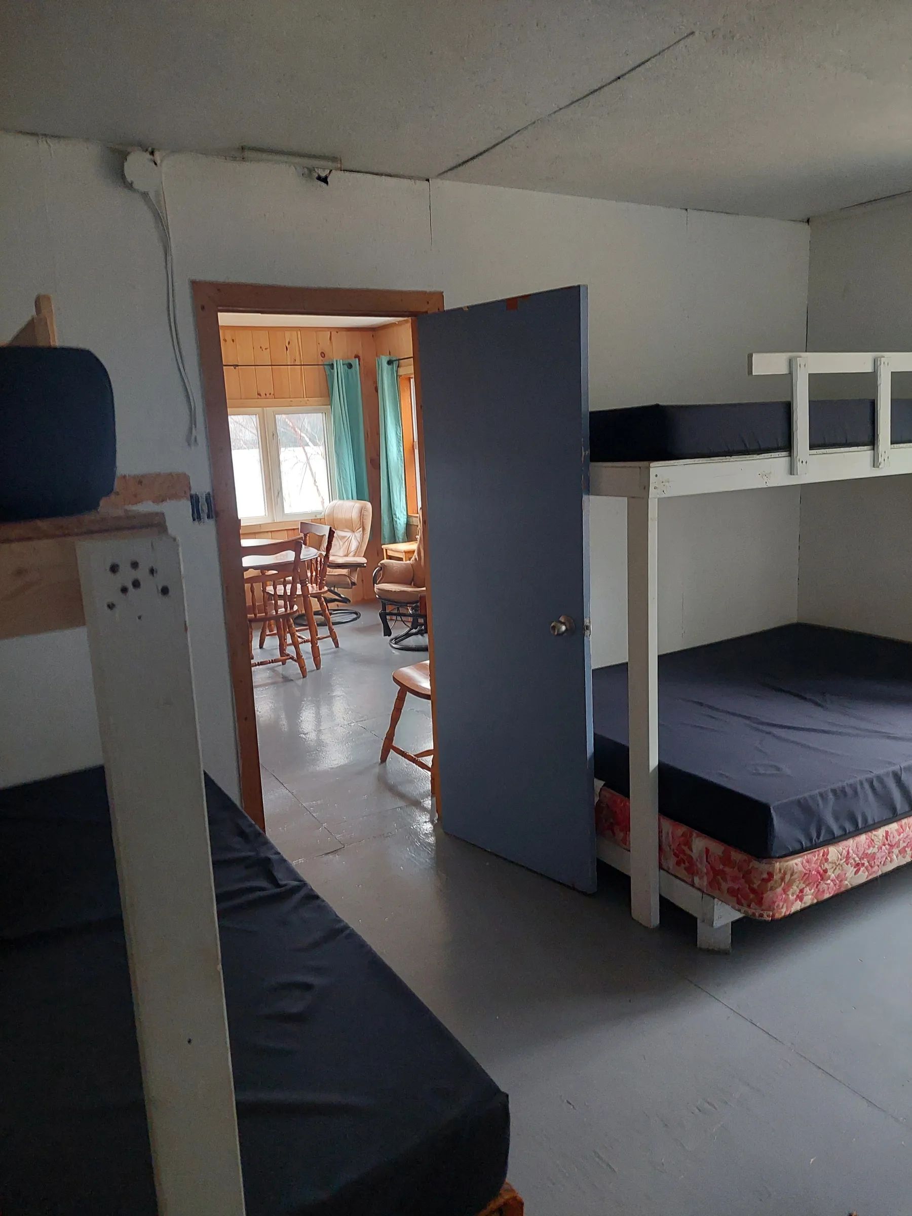 View of the bedroom with bunk beds and the dining area of the Le Huard cabin.