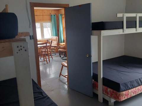 View of the bedroom with bunk beds and the dining area of the Le Huard cabin.