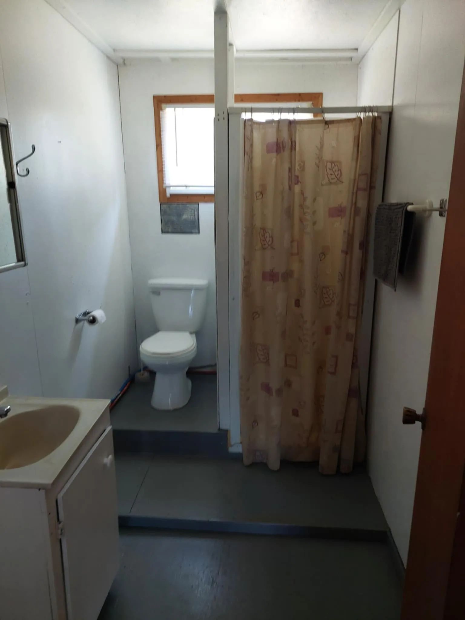 View of the functional bathroom with shower and toilet in the L'Aigle cabin.