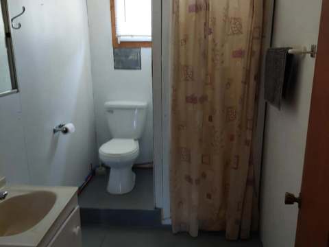 View of the functional bathroom with shower and toilet in the L'Aigle cabin.