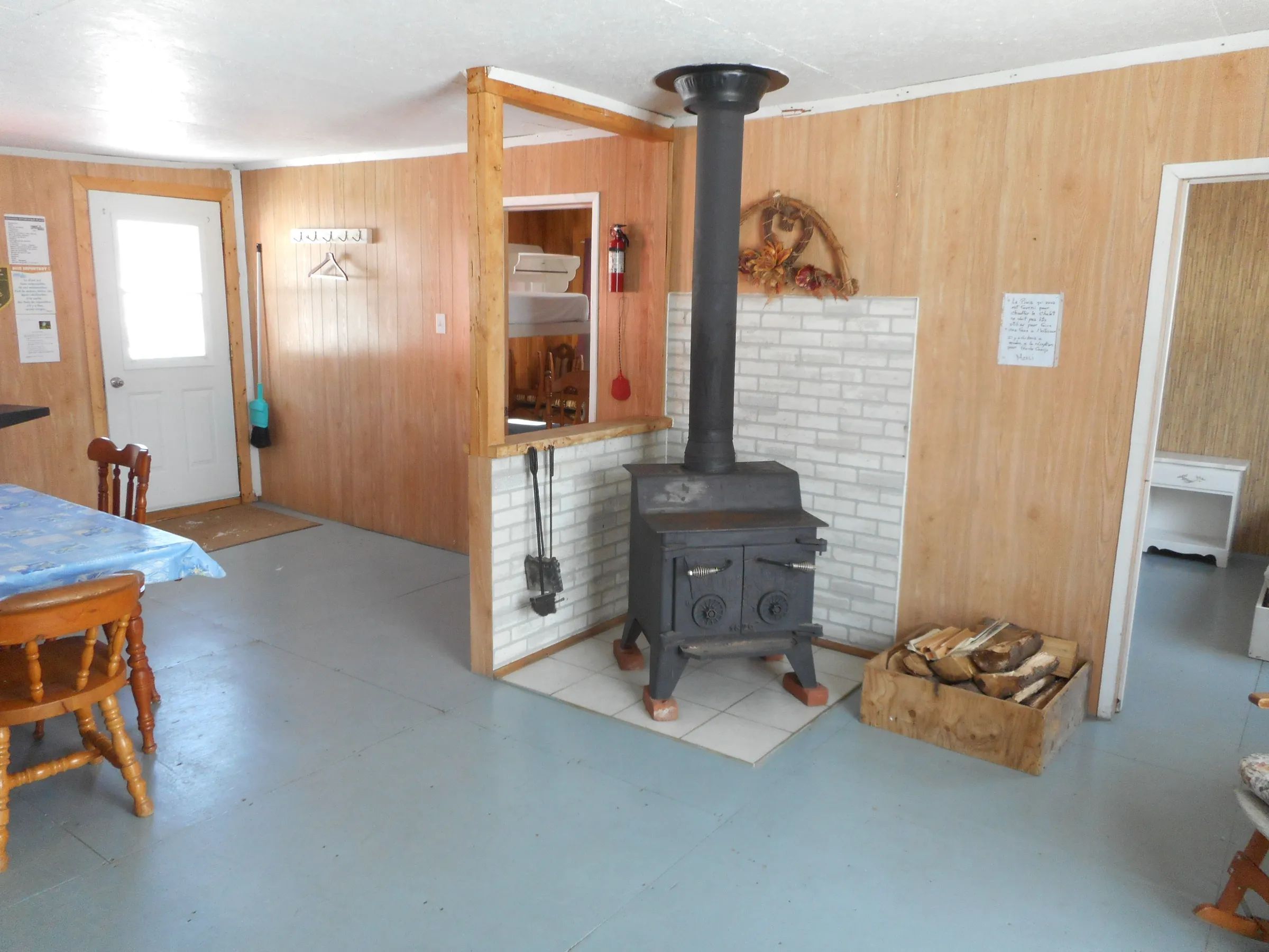 The dining area of Le Papillon cabin features a wood stove and a table for meals.