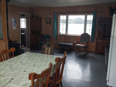 The cottage dining and living area offers a view of the lake.