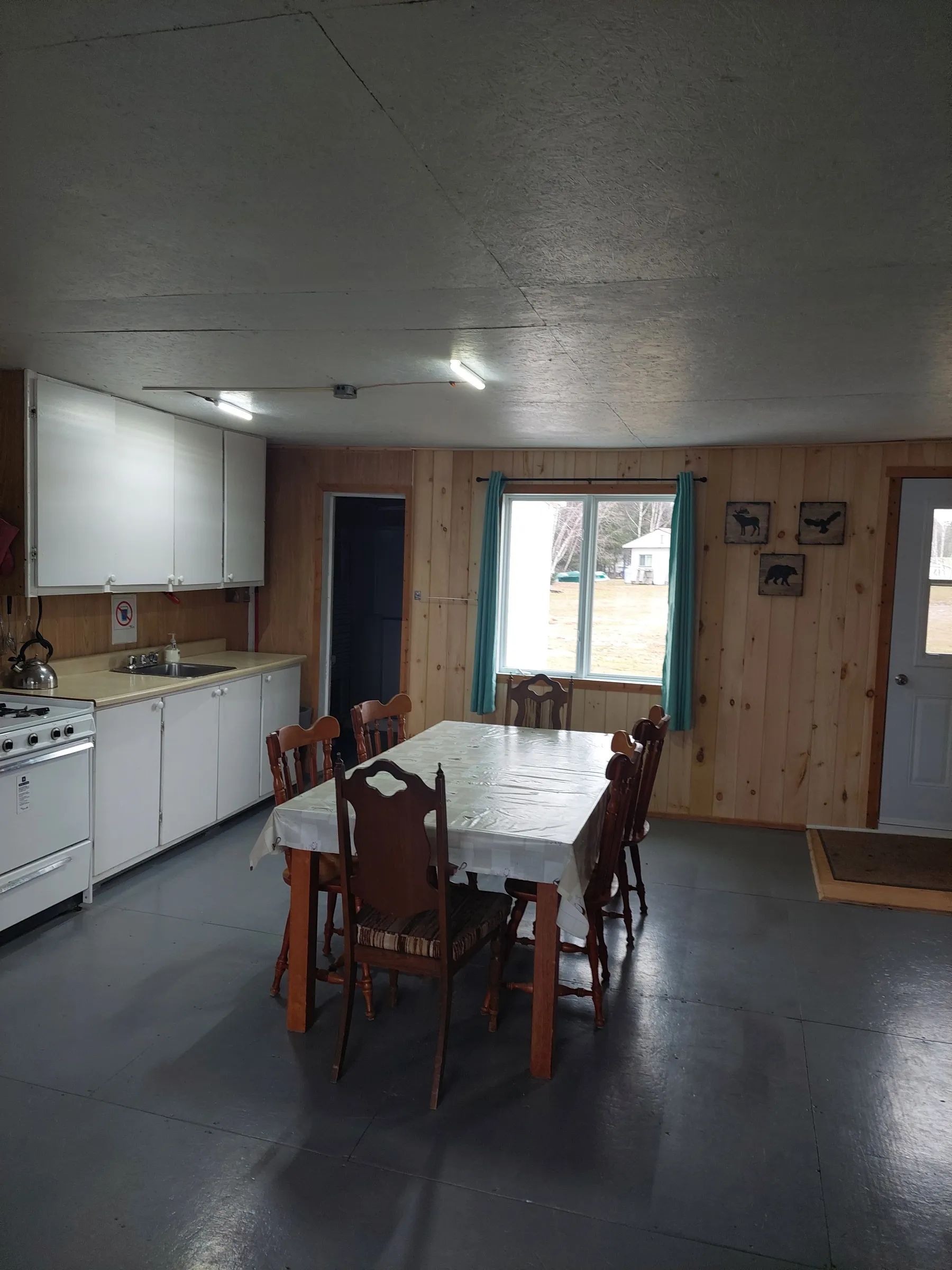 The functional kitchen of Le Papillon cottage includes a dining table and a stove.