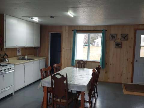 The functional kitchen of Le Papillon cottage includes a dining table and a stove.