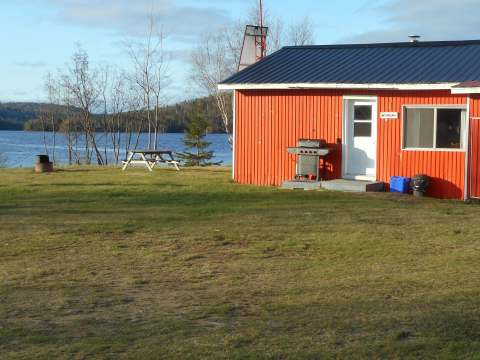 The Papillon cabin features a barbecue and a picnic table near the lake.