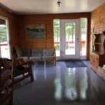 L'intérieur du chalet Le Canot offre un espace de séjour chaleureux avec des murs en bois rond.