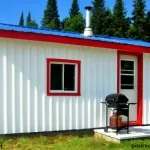 Le chalet Le Coquet présente un revêtement blanc avec des finitions rouges et un barbecue à l'extérieur.