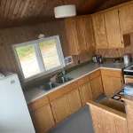 La cuisine fonctionnelle du chalet Le Familial est équipée de nombreuses armoires en bois.