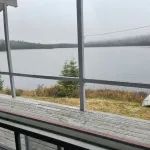 Vue sur le lac depuis la galerie grillagée du chalet Le Familial.