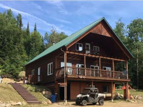 Vue d'ensemble du chalet Le Panoramique avec sa grande galerie et son accès extérieur.