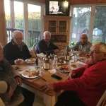 Un groupe partage un repas dans la salle à manger lumineuse du chalet Le Panoramique.