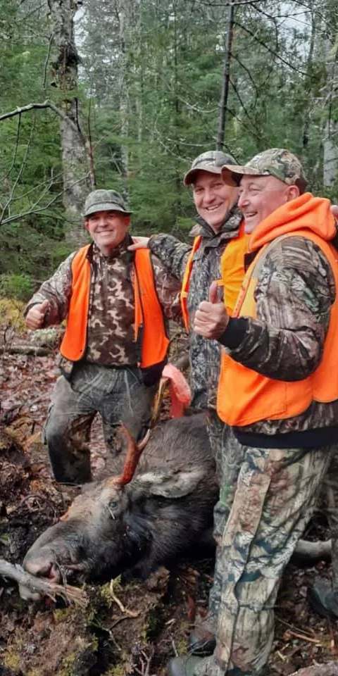 Groupe de chasseurs célébrant la fin de saison de chasse à l'orignal chez Pourvoirie Rudy, Laurentides, Québec