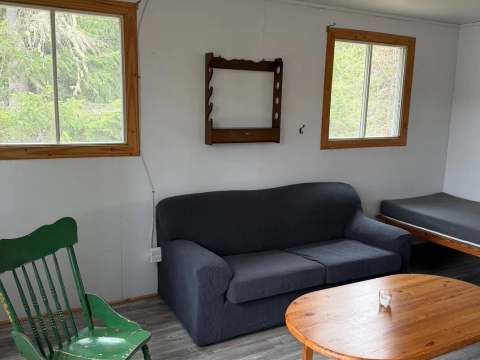 The cottage living area features a sofa, a coffee table, and a rocking chair.