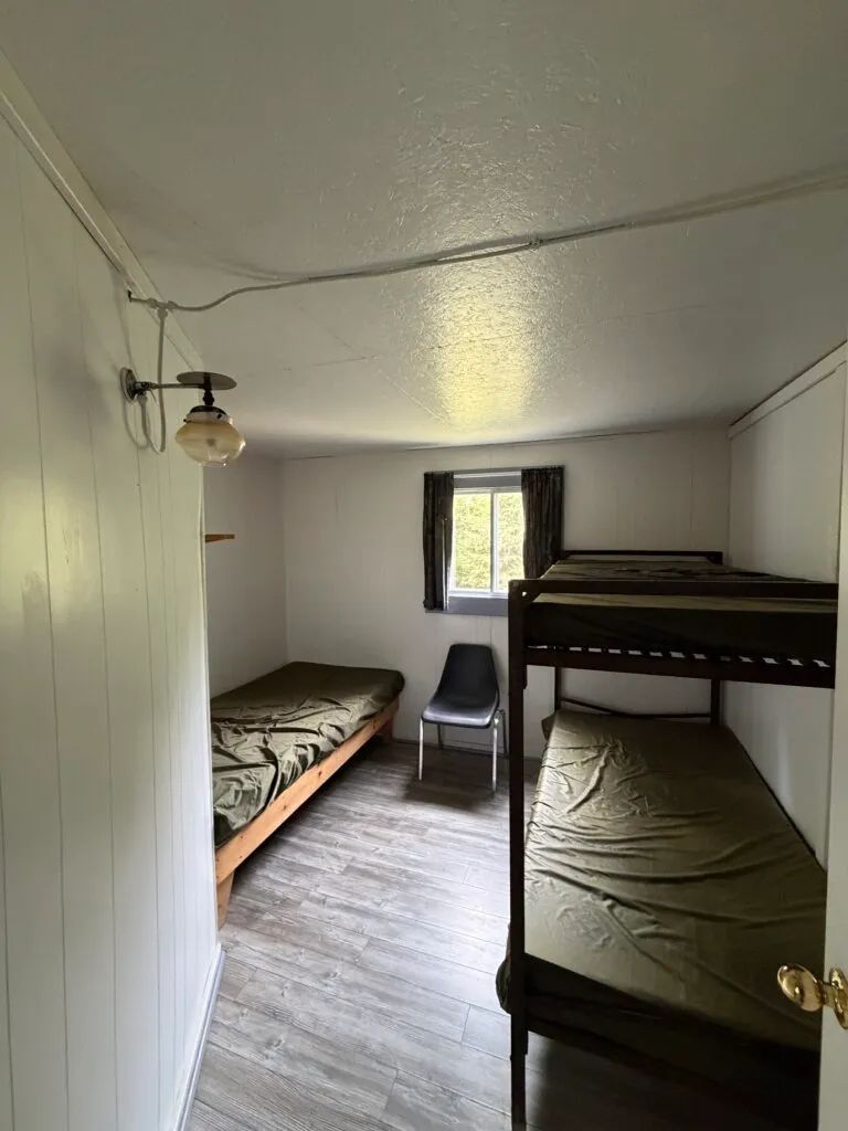 This bedroom in cabin 3 features a single bed and a bunk bed.