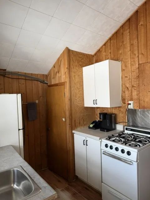 The functional kitchen of cottage 3 is equipped with a stove, a refrigerator, and a coffee maker.