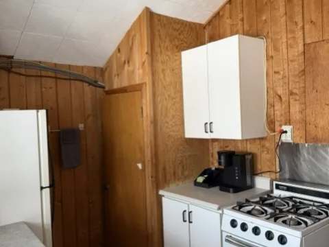The functional kitchen of cottage 3 is equipped with a stove, a refrigerator, and a coffee maker.