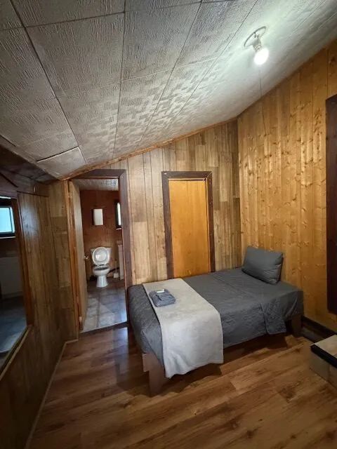 This rustic bedroom features a single bed and direct access to a private bathroom.