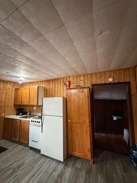 The cottage's equipped kitchen features a stove, a refrigerator, and wooden cabinets.